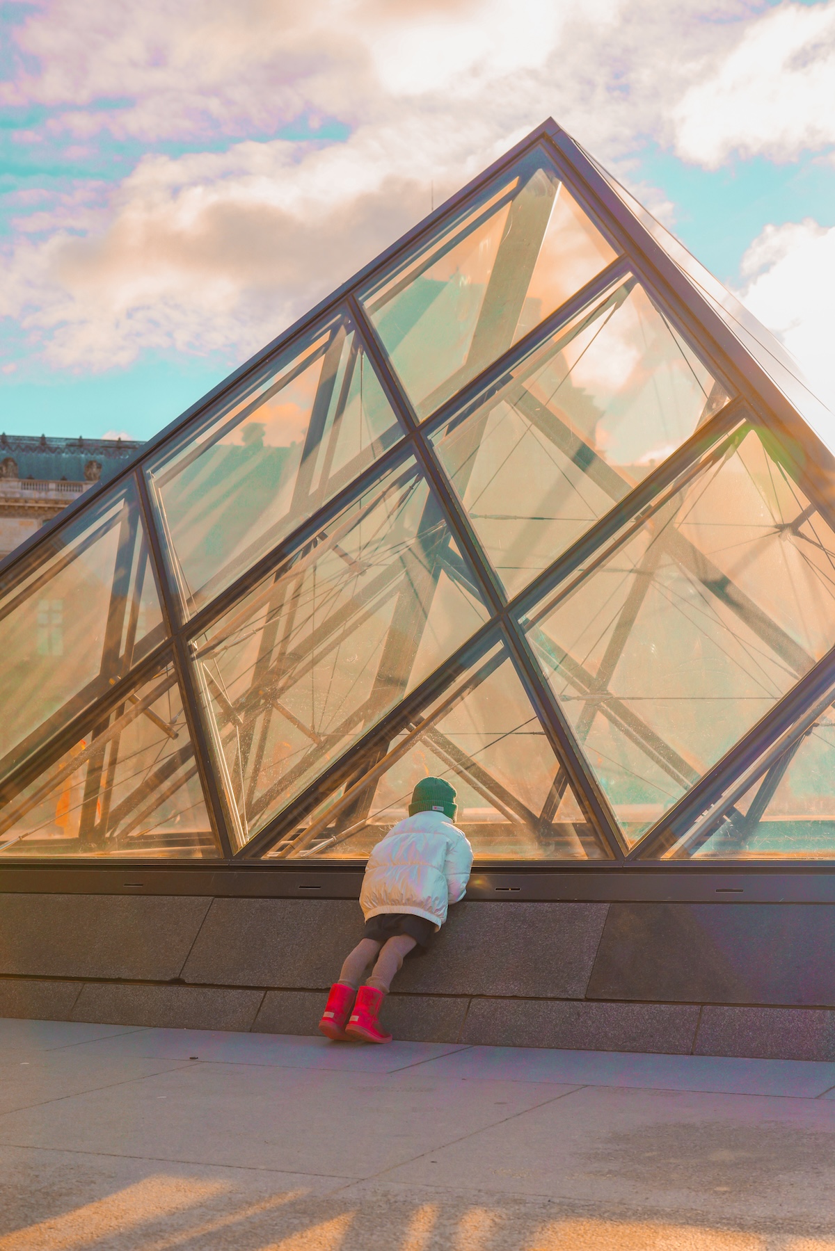 Louvre on a sunny day child leaning on glass